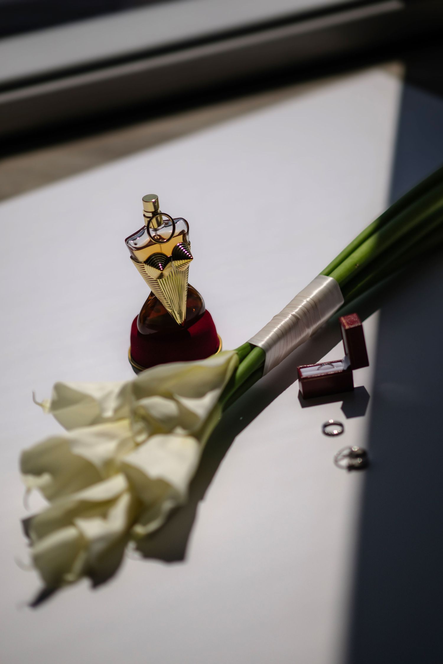 A close-up image of a ring and flowers on a white background.