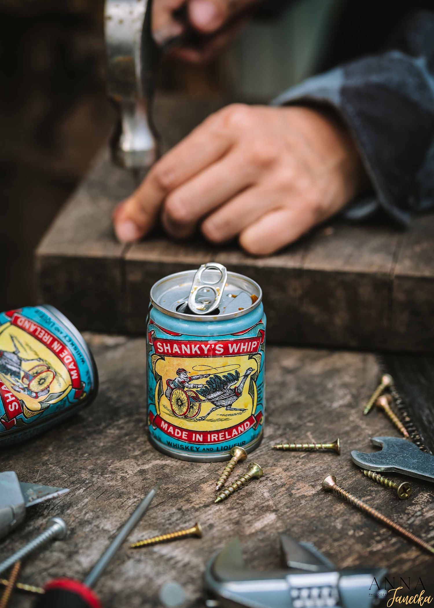 Vintage style sardine can on weathered wood surface with tools and screws.