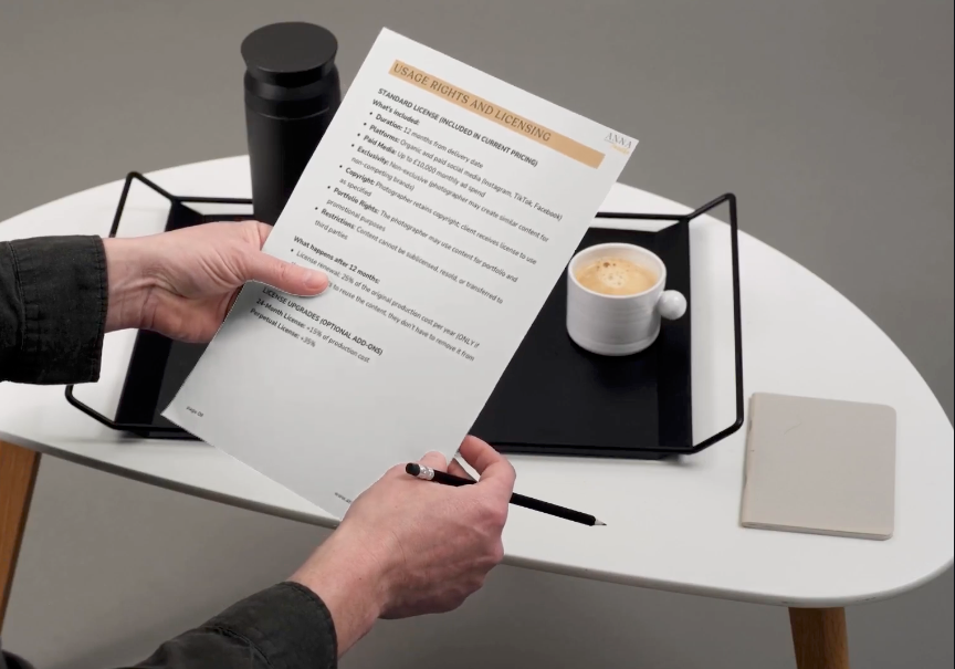 Business professionals reviewing and signing documents at a meeting table with coffee cups present.