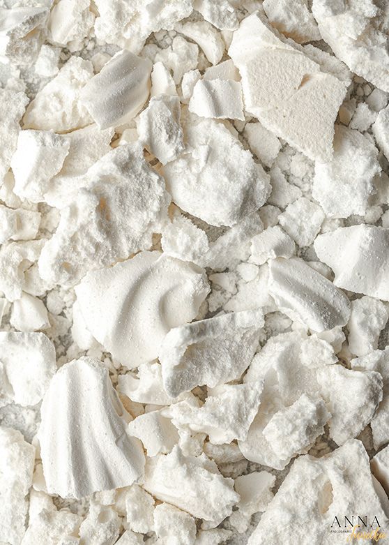 Crushed meringue pieces and powder creating a textured white background.