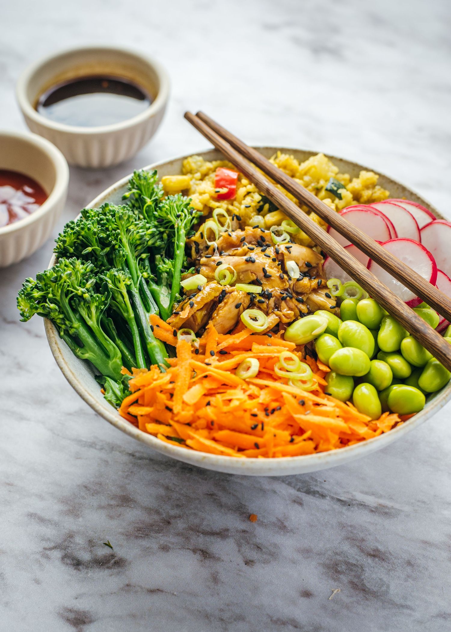 Four stages of assembling a colorful Asian Buddha bowl with broccoli, edamame, noodles, and shredded carrots.