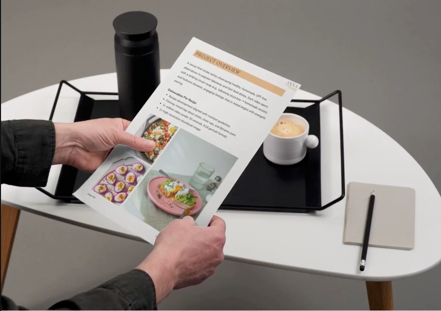 Hands holding business cards and documents across a modern office desk during a professional meeting.