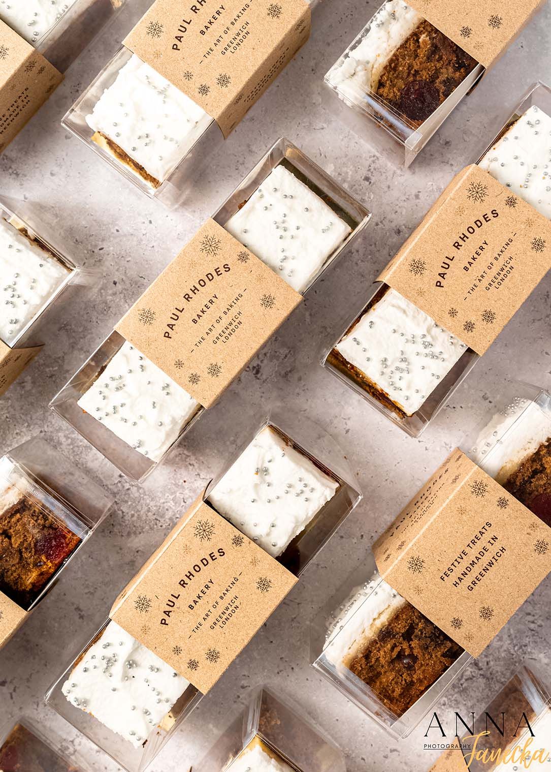 Overhead view of Paul Rhodes bakery boxes arranged diagonally on light surface.