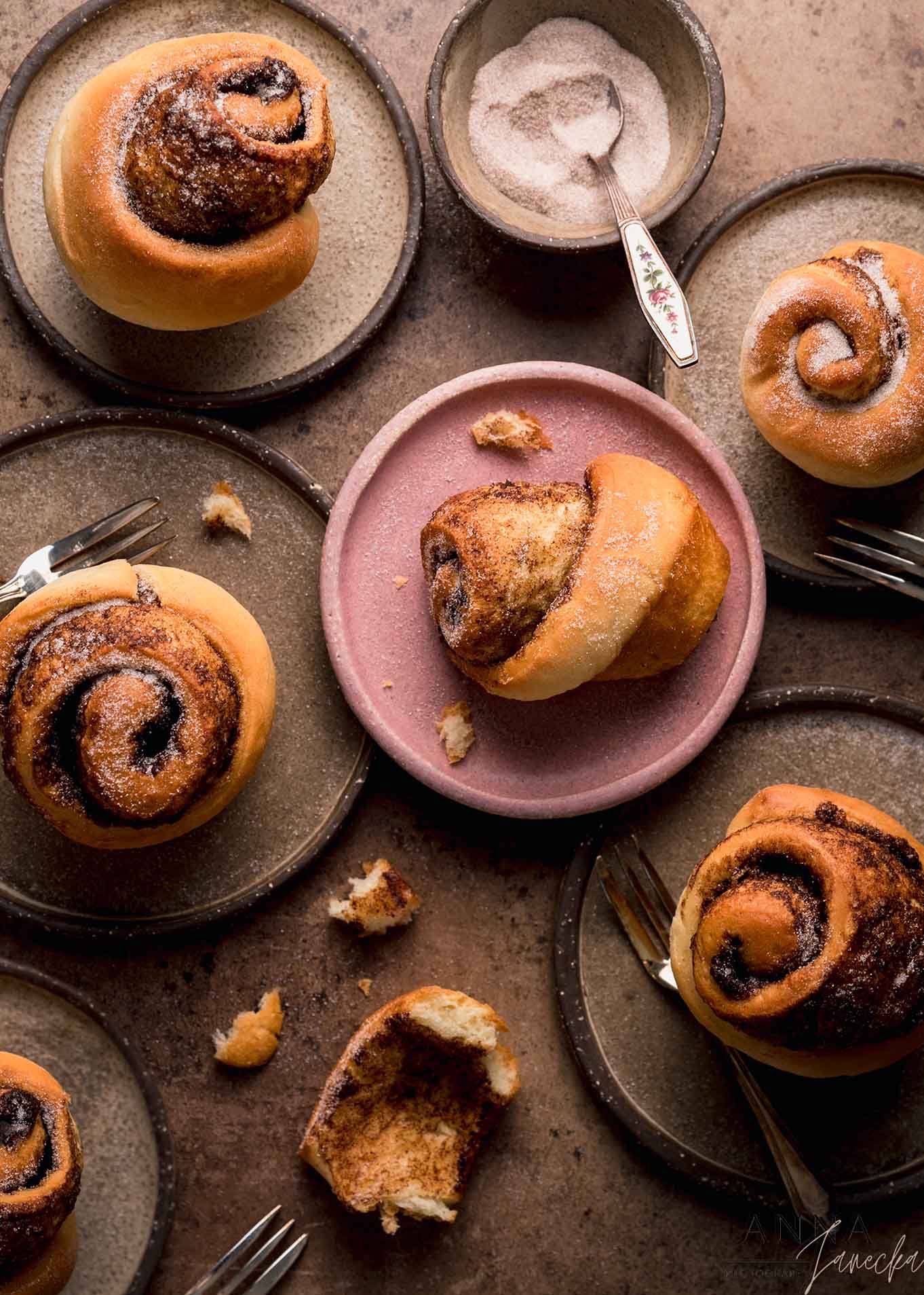 Freshly baked chocolate swirl buns arranged on dark plates with rustic styling.