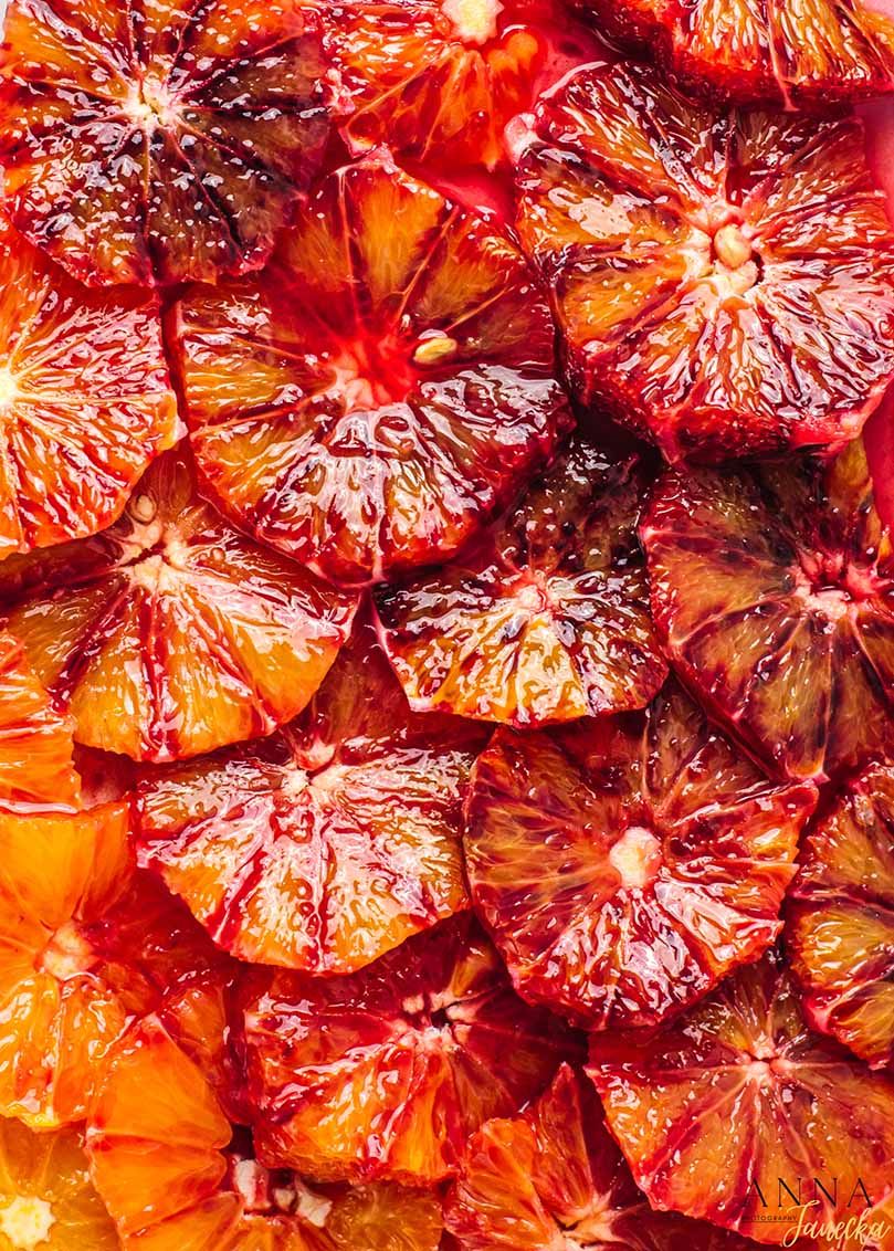 Close-up of vibrant red blood orange slices arranged in a pattern.