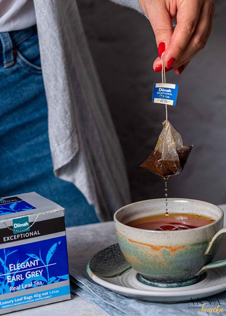 Steeping tea bags in ceramic bowls with boxes of different tea varieties displayed.