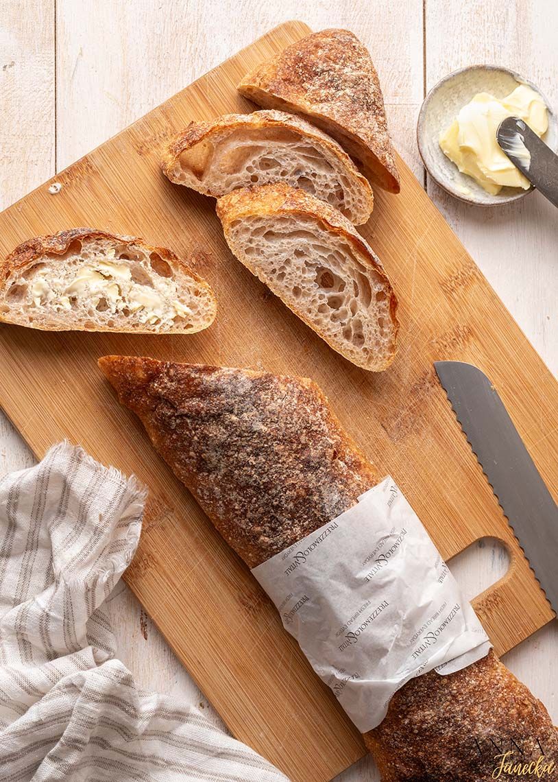 Freshly baked artisanal bread loaves sliced on wooden cutting boards.