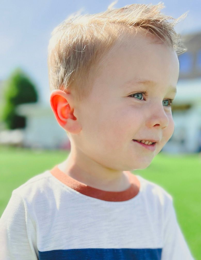 Portrait of young child with light hair outdoors on a sunny day.