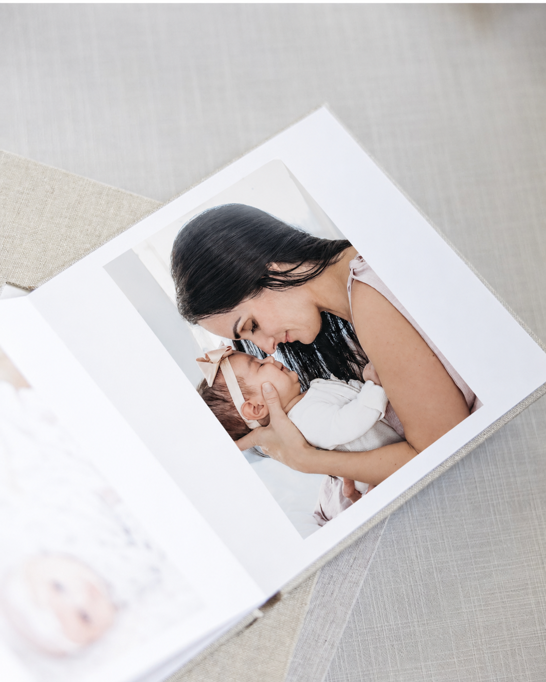 Mother cuddling her newborn in a custom heirloom photography album