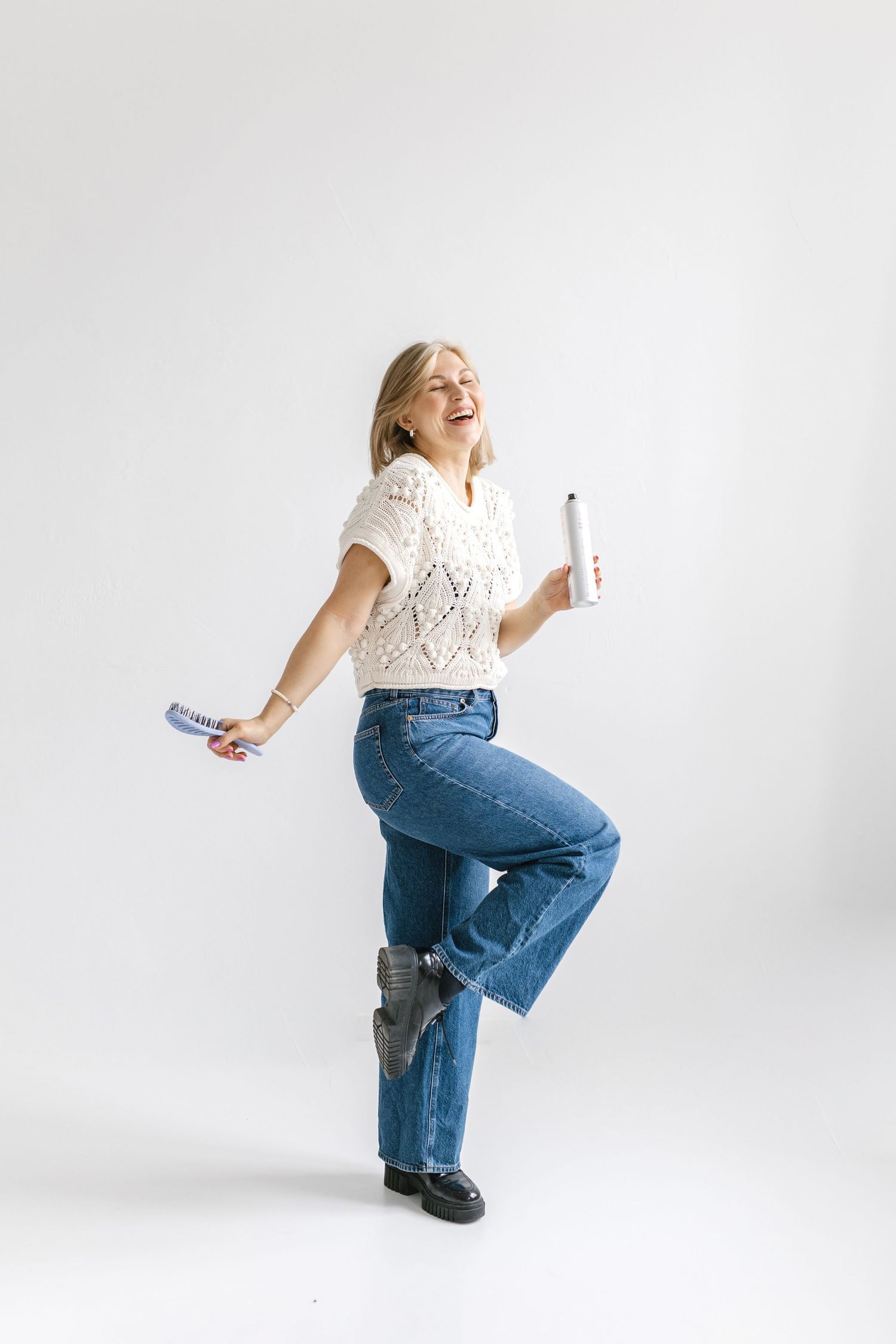 A person in blue jeans and a white top poses playfully against a white background in a series of dynamic shots.