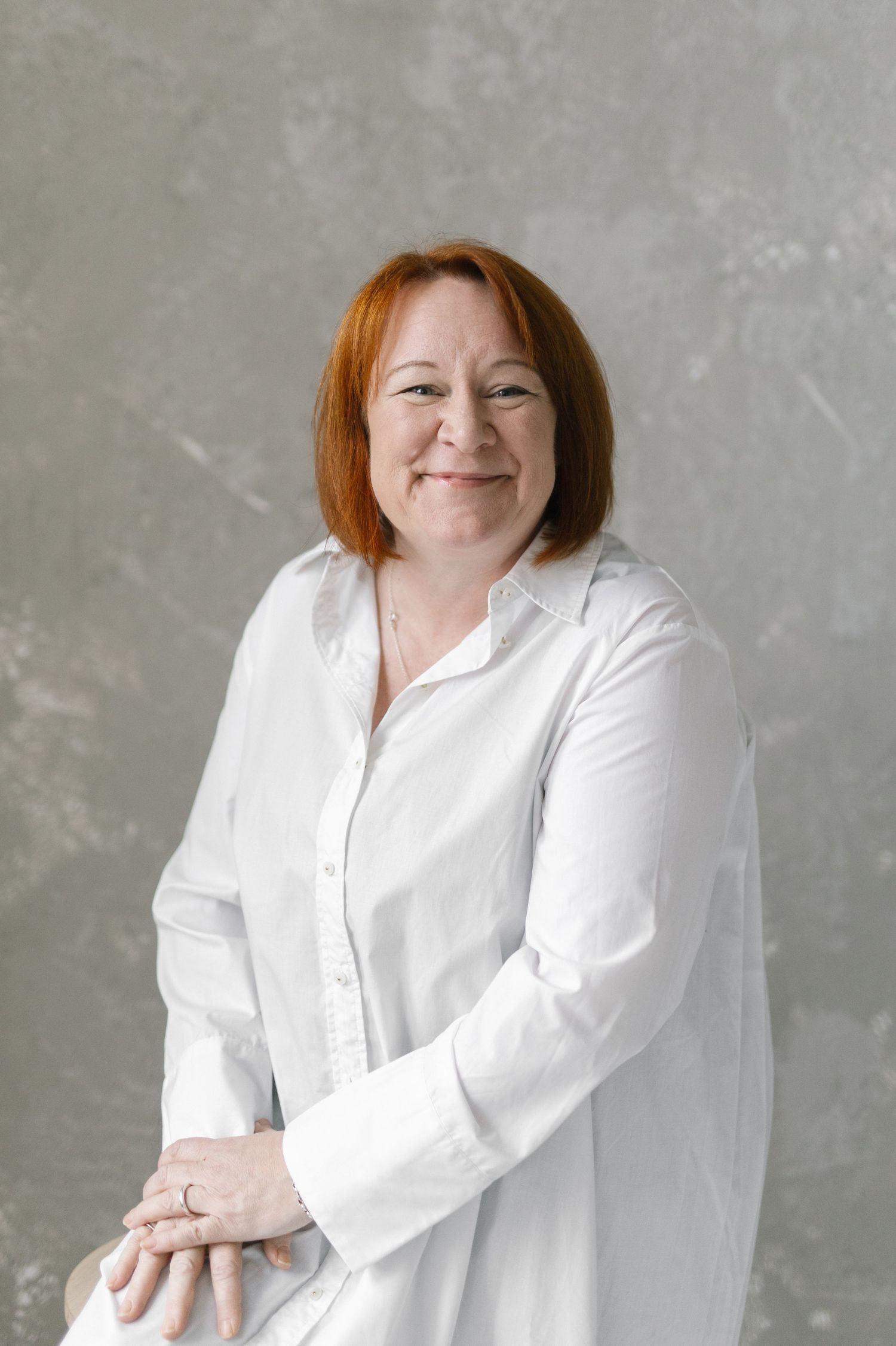 Studio portraits in a white button-down shirt showing relaxed, natural poses.