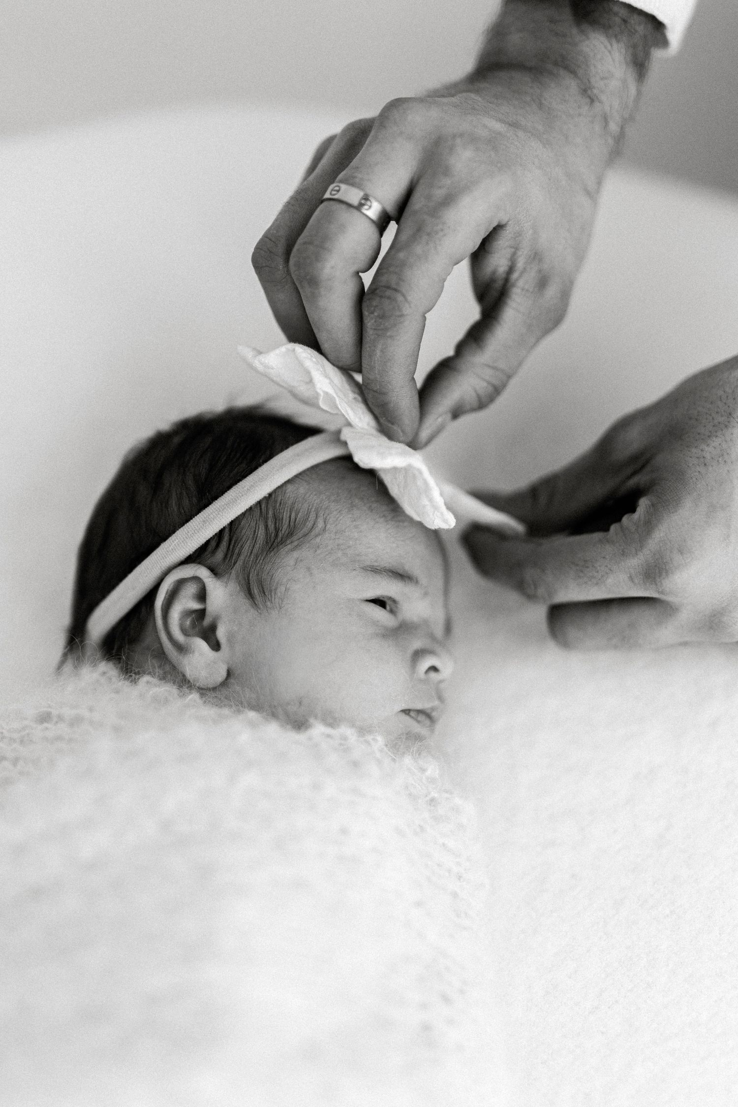 A sequence of black and white images showing someone getting their ears cleaned with cotton swabs in a soft cloud-like setting.
