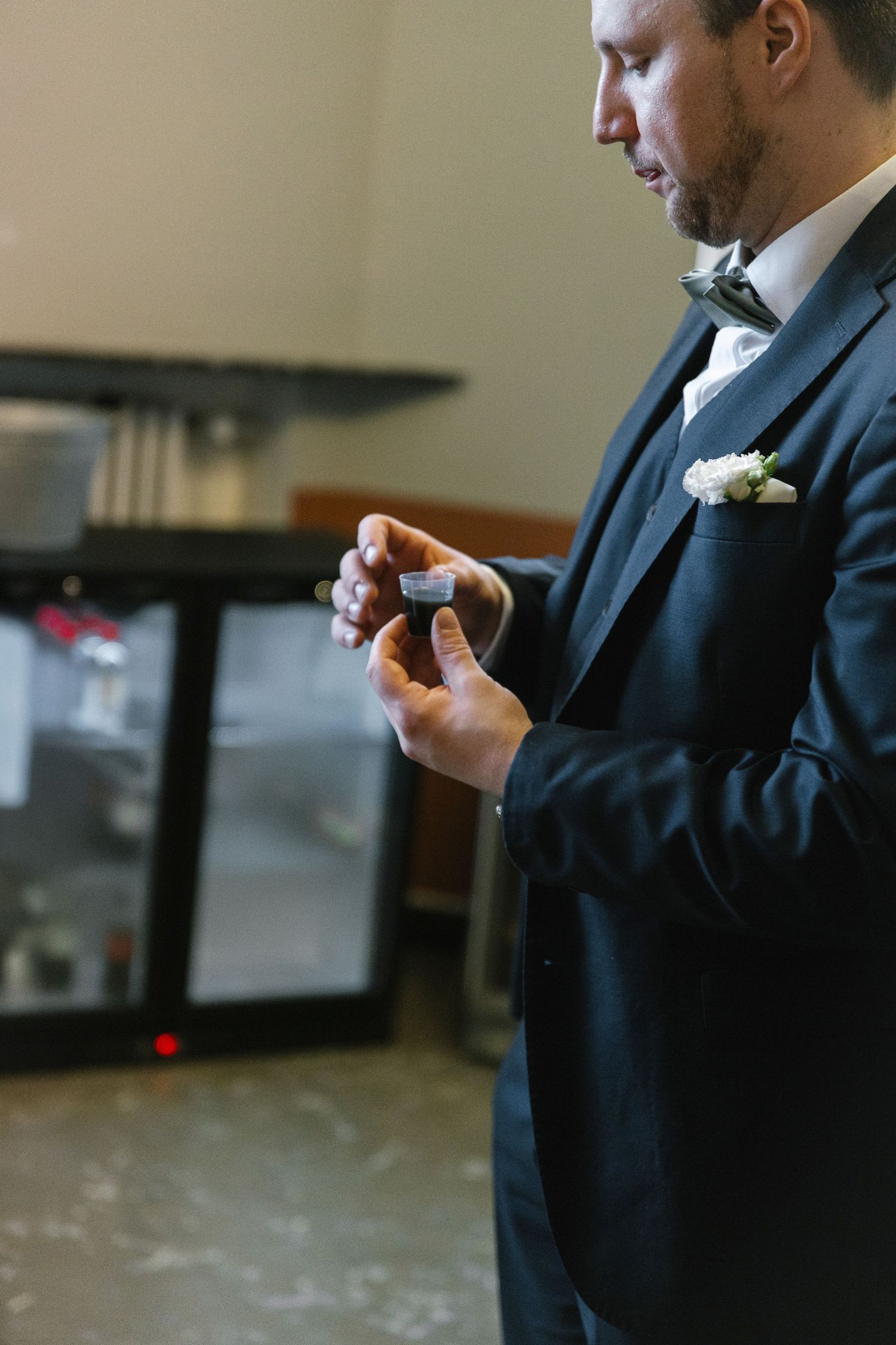Close-up shot of someone in a dark suit holding a small object.