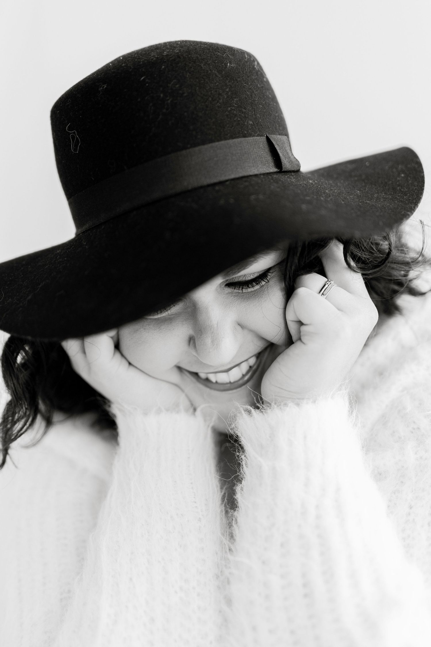 Artistic black and white portraits with person wearing hat showing genuine smiles.