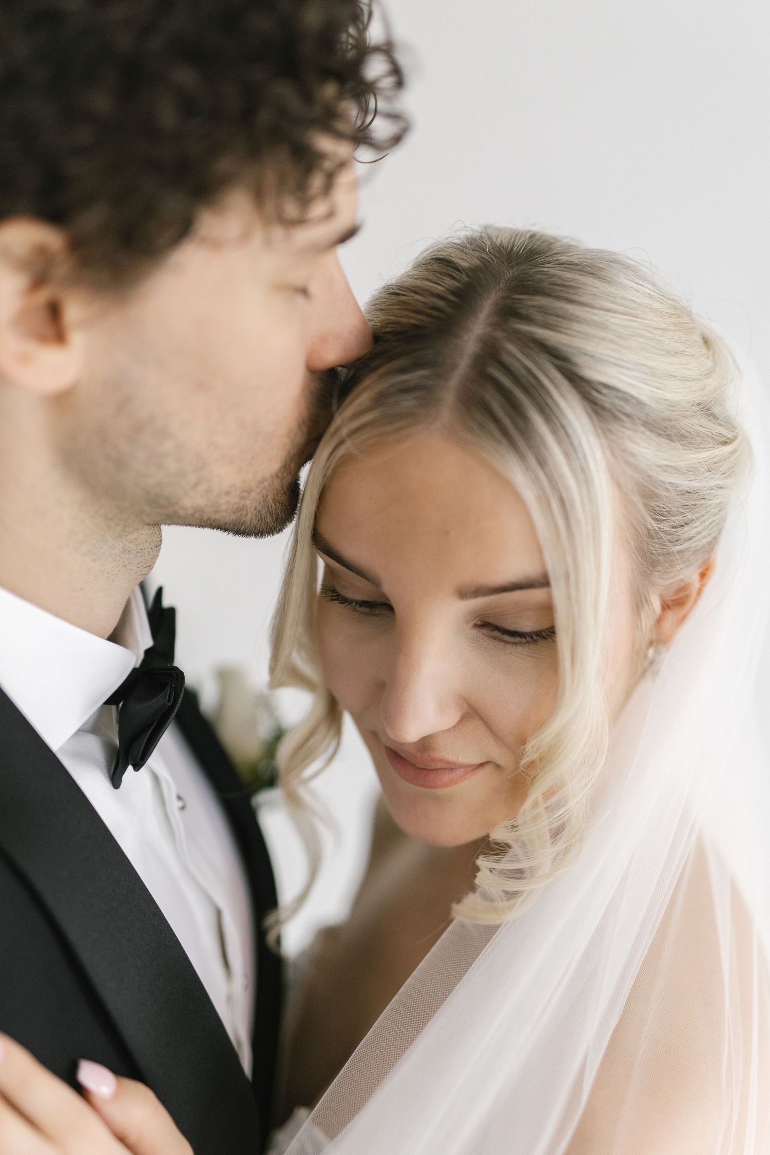 Intimate close-up wedding portrait showing tender moment between newlyweds.