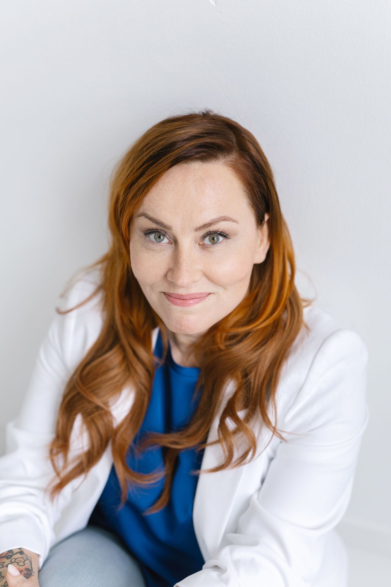 Professional portrait series showing expressive poses in a white blazer and blue top against light background.