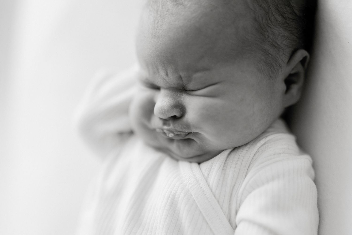 Artistic black and white portraits capturing a newborn's peaceful sleeping expressions.
