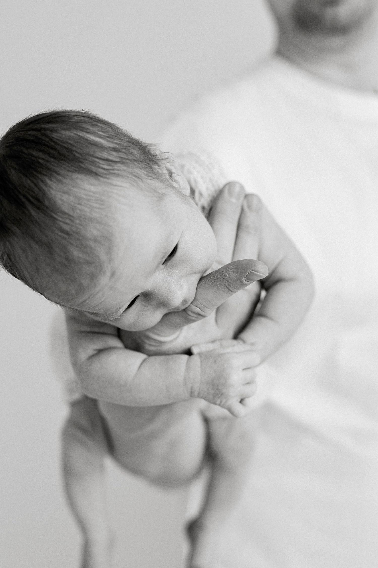 Close-up black and white portraits of sleeping infant in artistic composition.