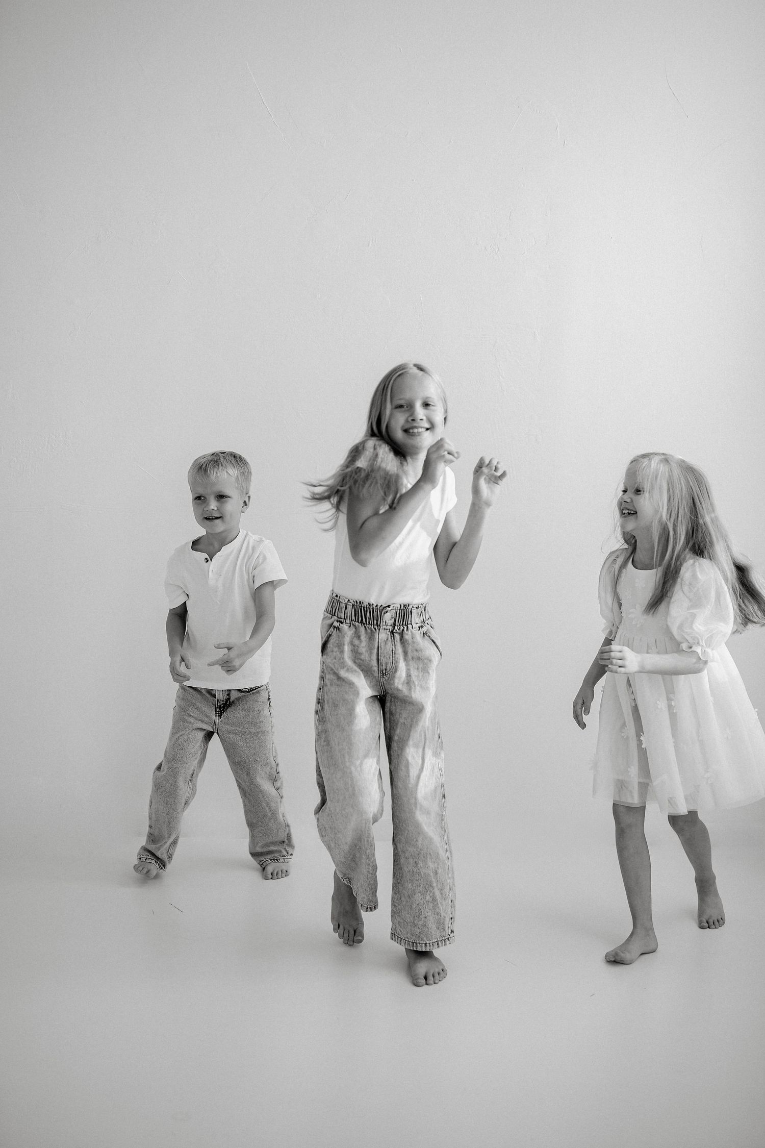 Black and white photo series of playful family dance movements.