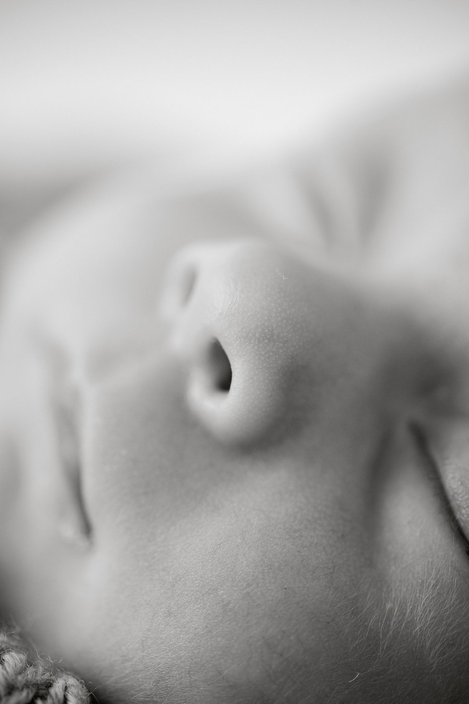 Close-up black and white macro photo of a sleeping newborn baby's nose and lips.