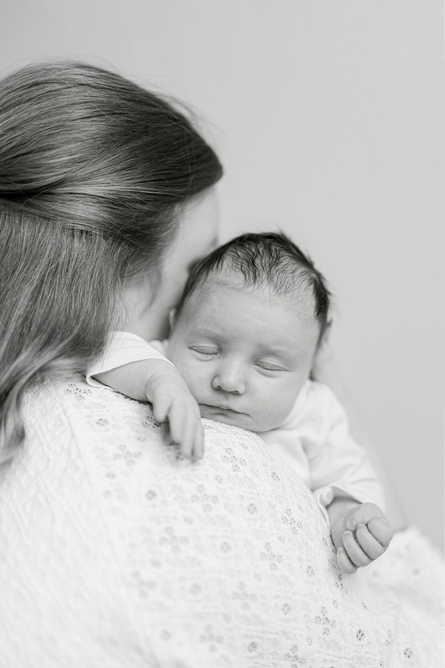 Intimate black and white portraits of parent and baby in tender moments.