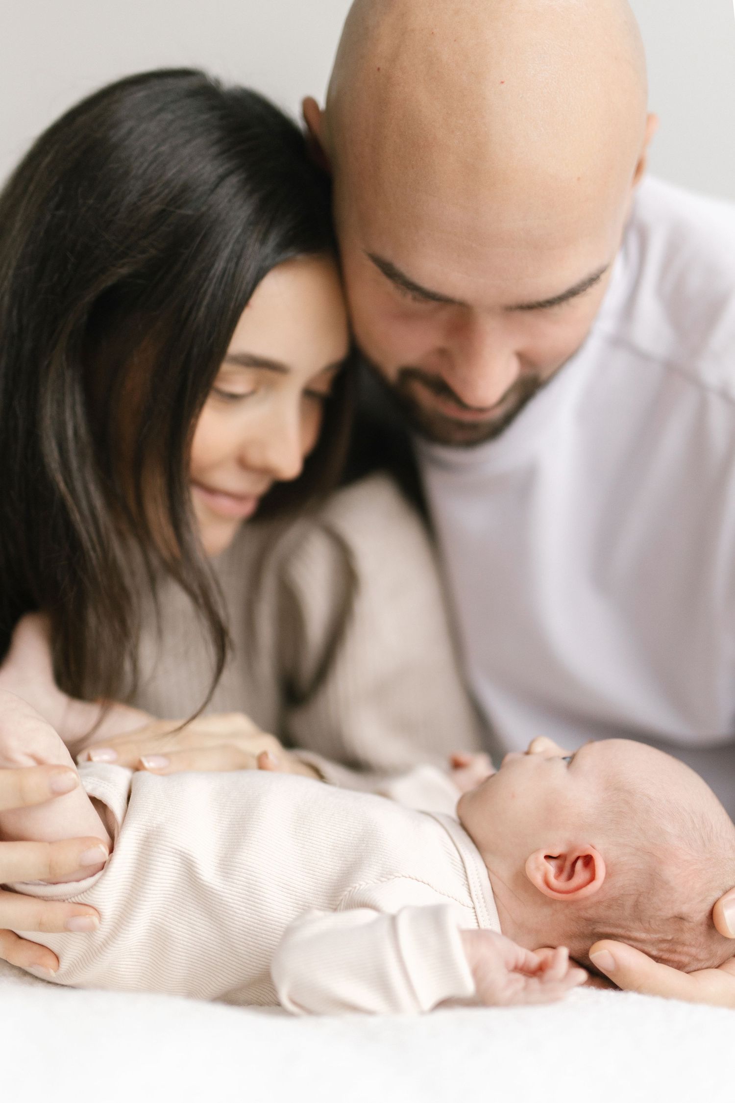 Intimate black and white portrait series of parents bonding with their newborn baby.