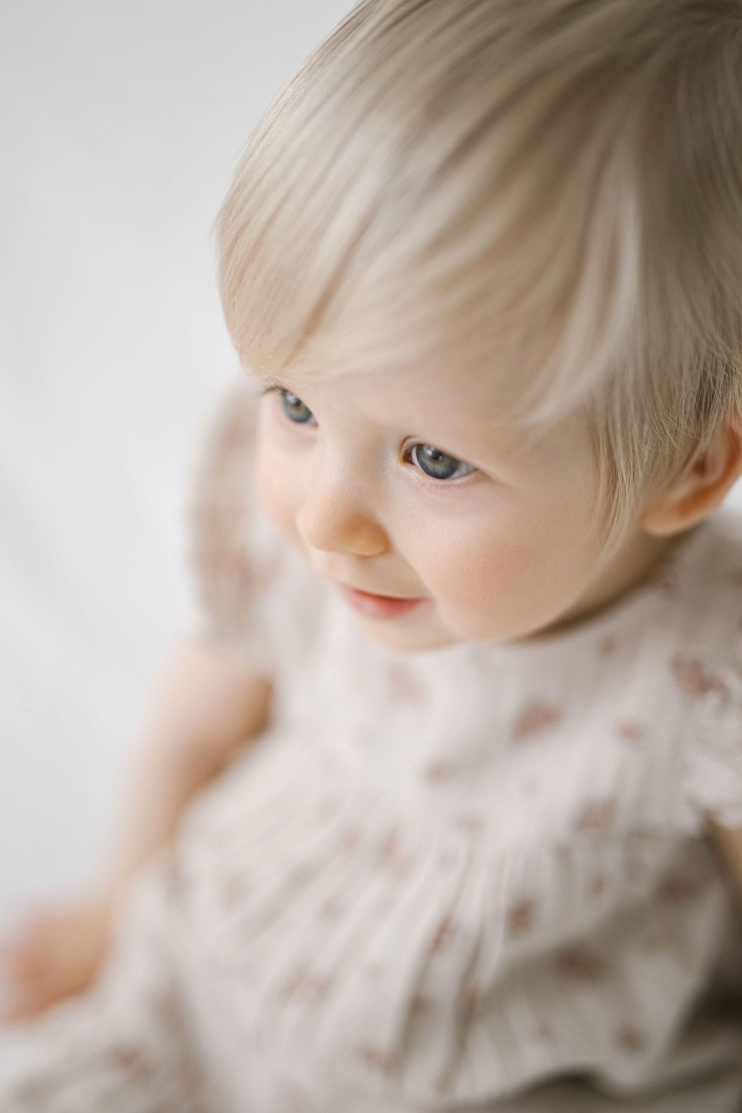 Gentle profile view of an infant wearing a knit sweater in soft natural light.