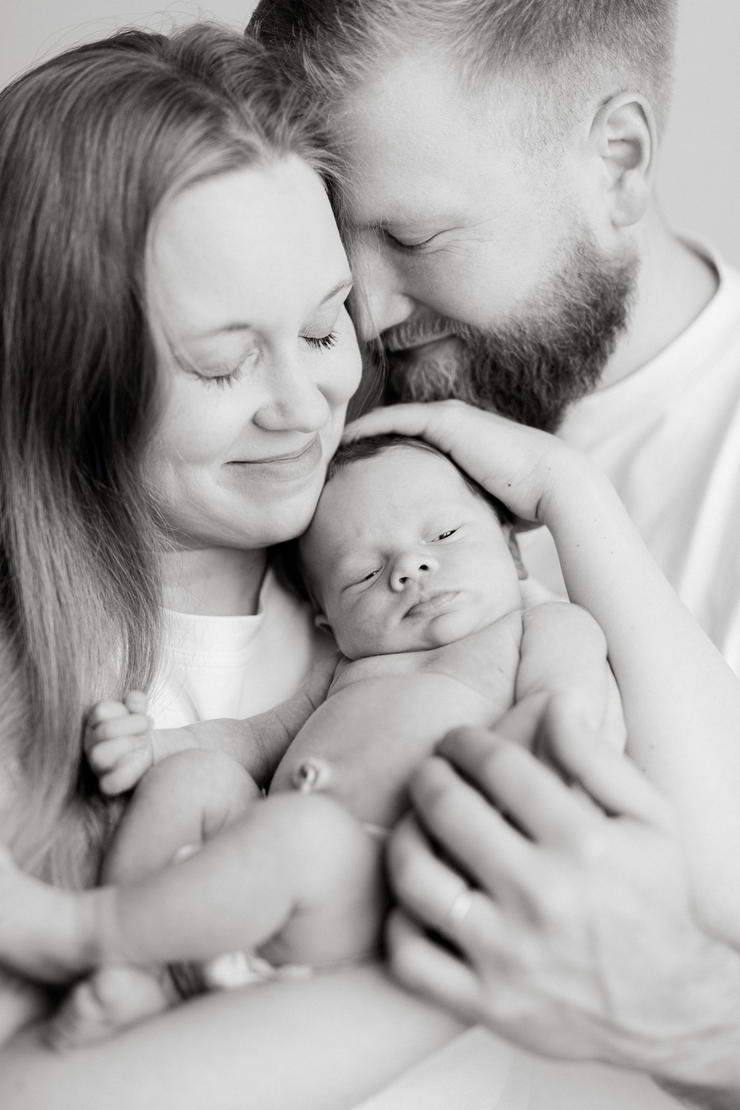 Intimate black and white family portrait with newborn baby.