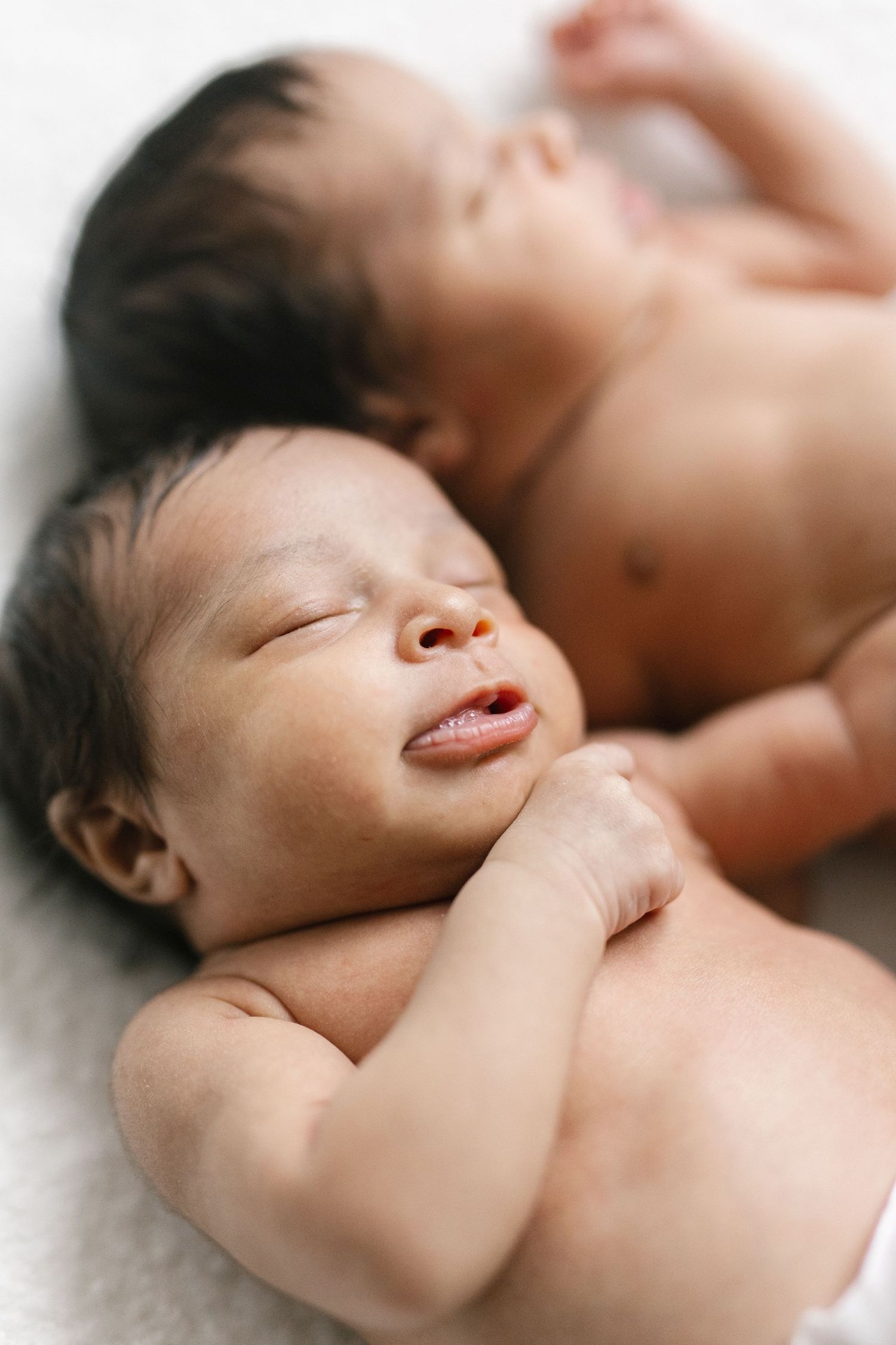 Artistic close-up photos of sleeping newborn showing delicate features and peaceful expression.