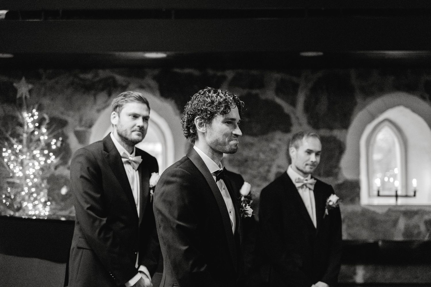 Black and white wedding party portraits in dramatic church setting.