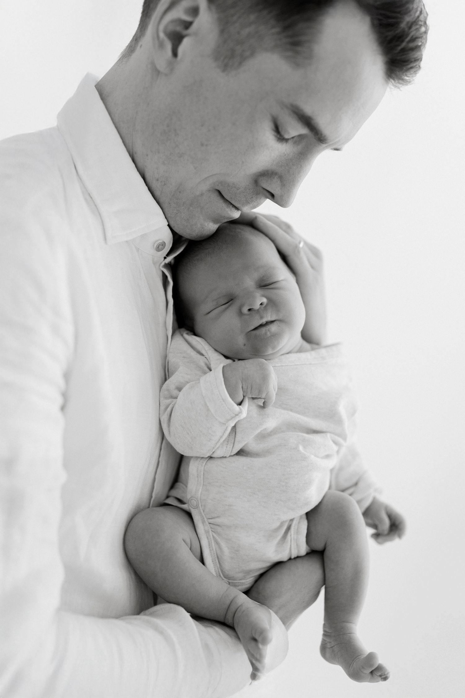 Intimate black and white portraits showing tender moments with a sleeping infant.