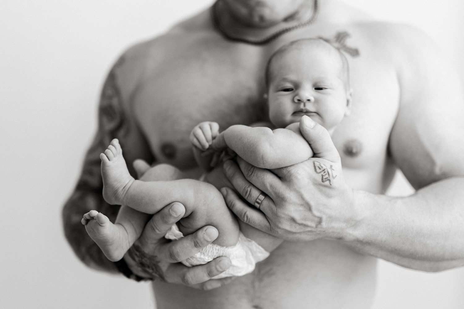 Black and white series of tender moments between parent and newborn.