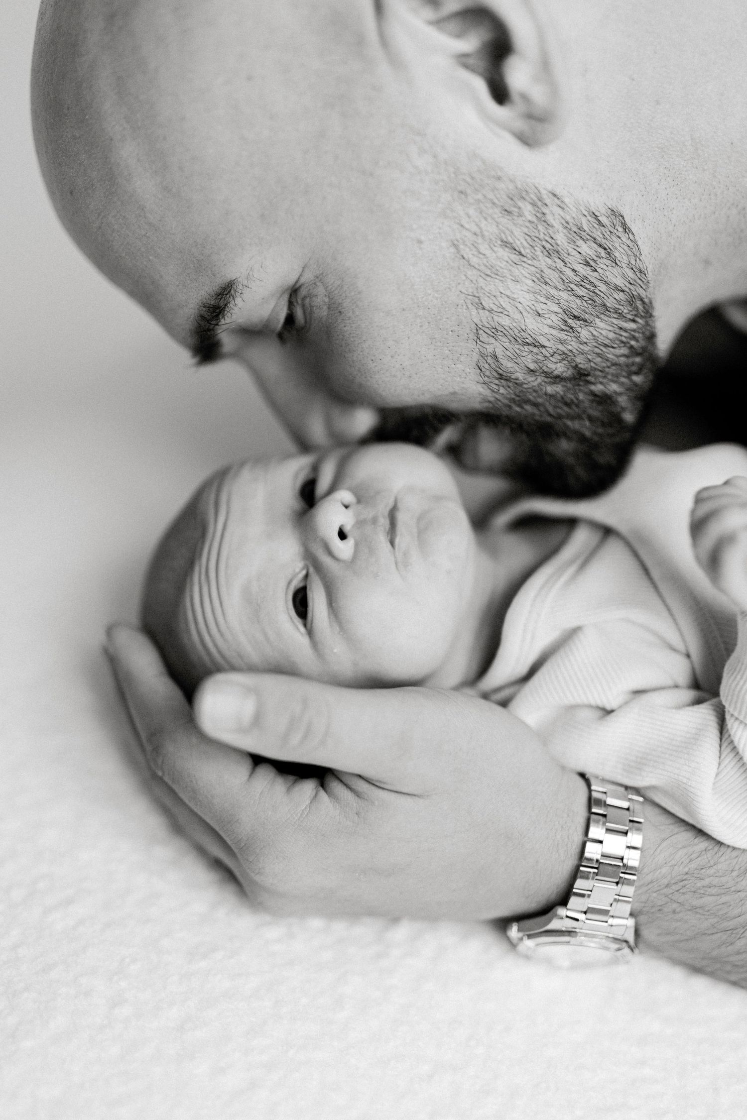 Close-up series showing gentle moments between a parent and sleeping infant.