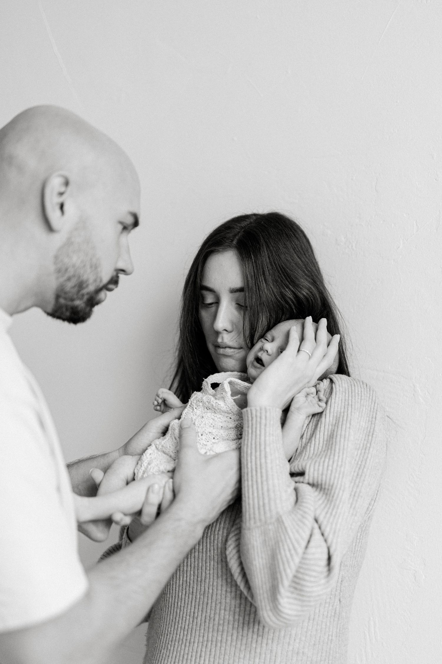 Black and white series capturing emotional moments between two people in soft lighting.