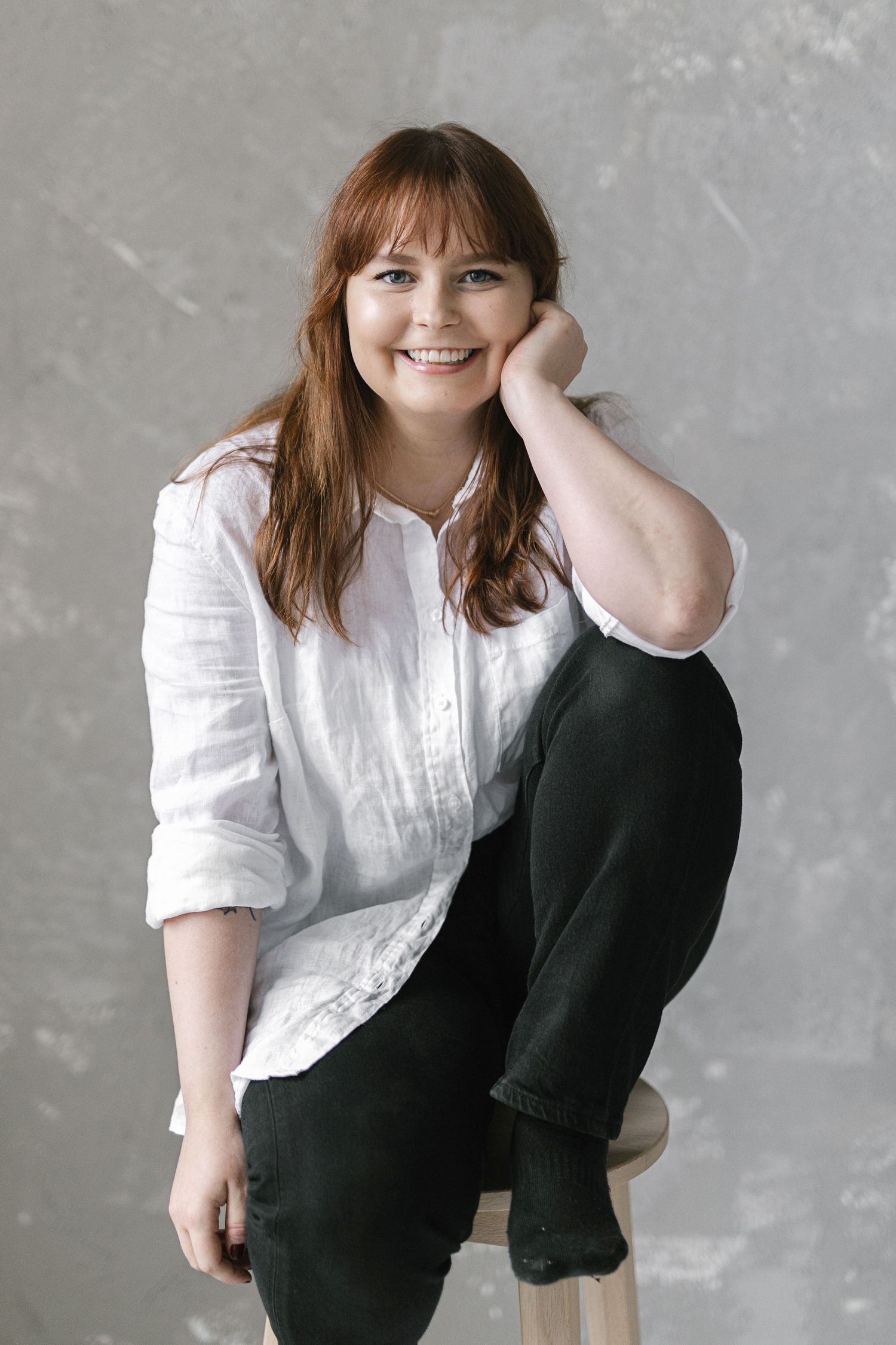 Casual portrait series in white shirt and black pants showing relaxed poses.