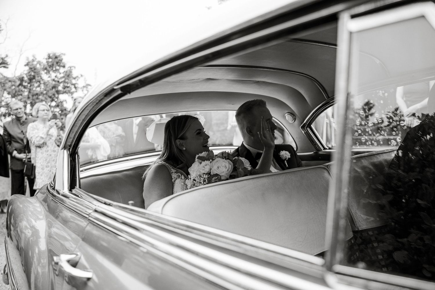 Black and white photos of classic car with passengers.