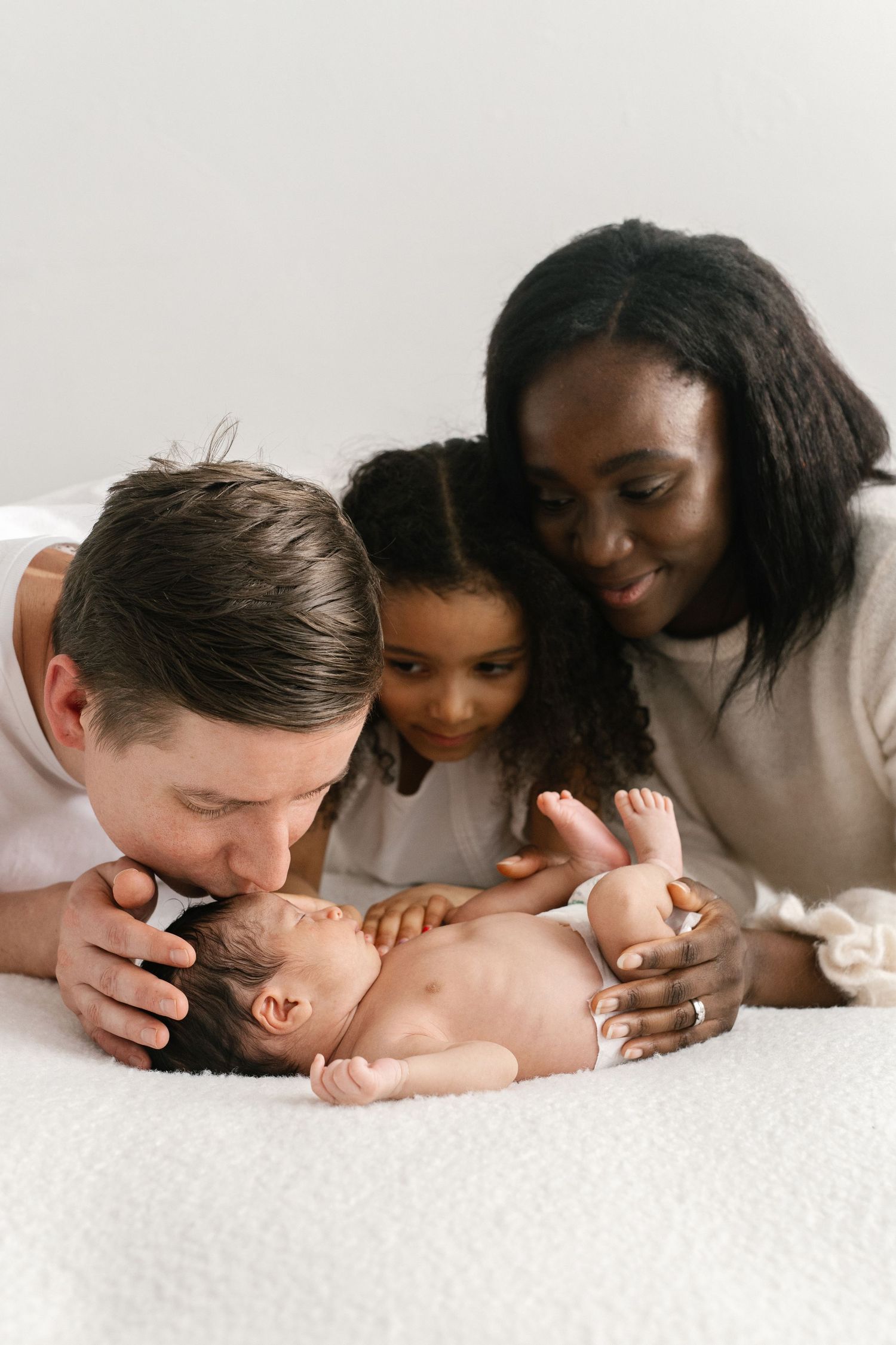 Progressive shots of parents sharing tender moments with their newborn baby.
