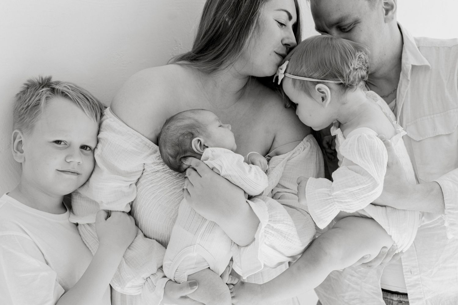 Intimate black and white family portrait during newborn feeding moment.