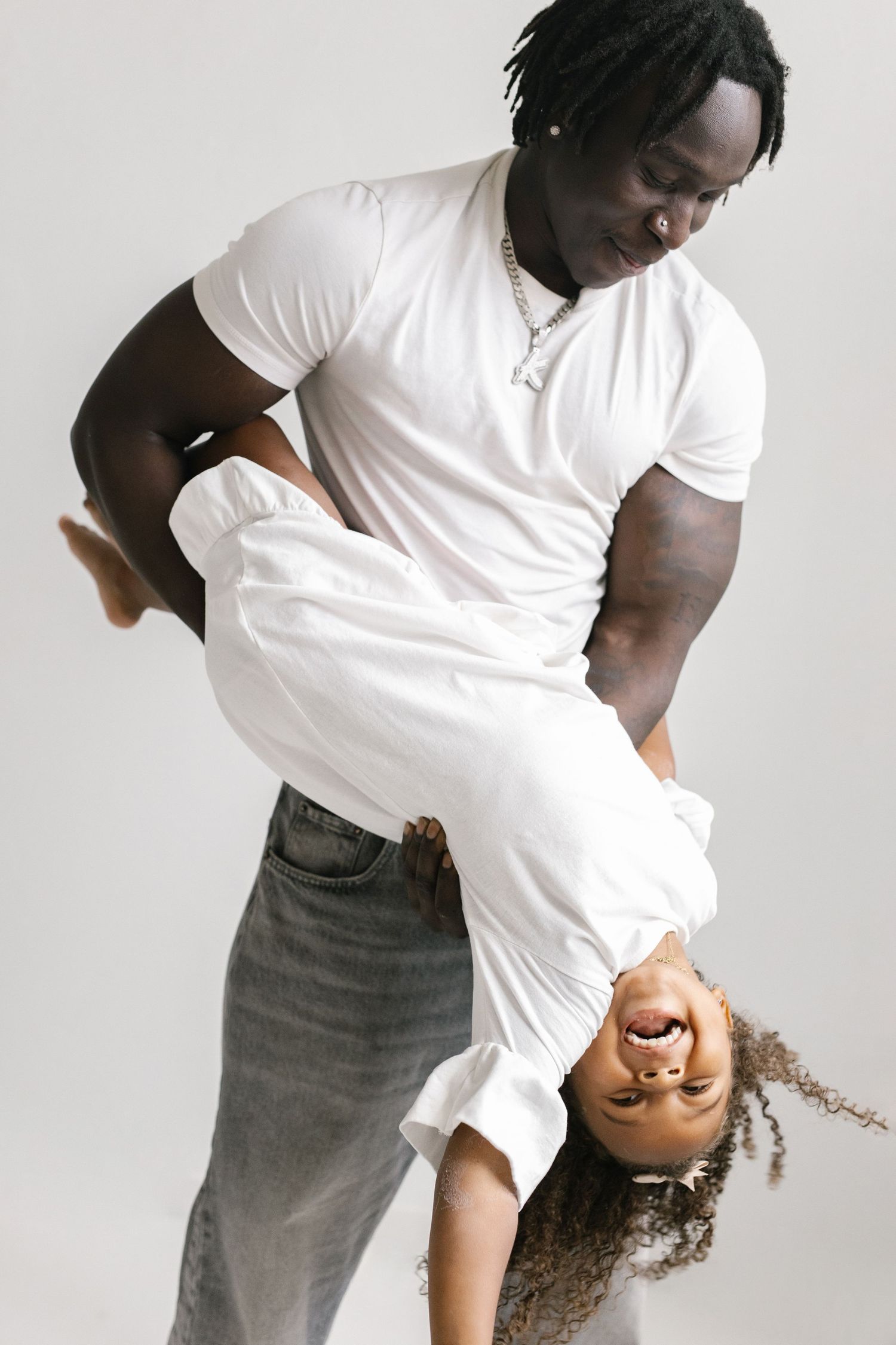 Artistic dance poses showing two people in white shirts against a light backdrop.