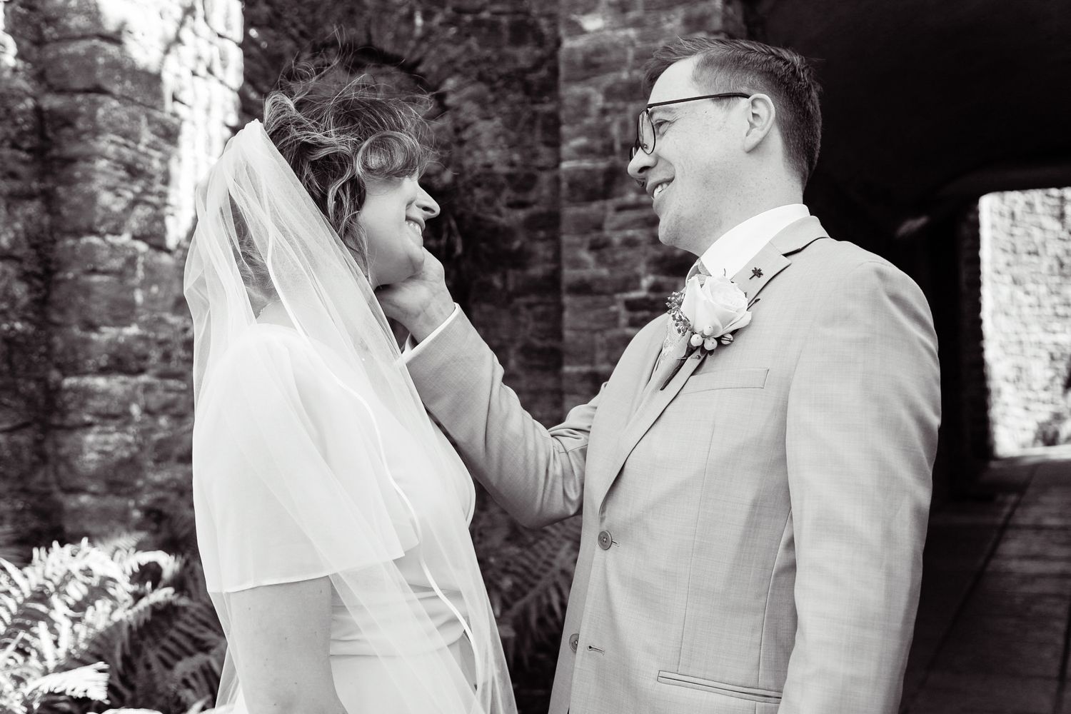 Wedding couple sharing intimate moments against a rustic brick wall backdrop.