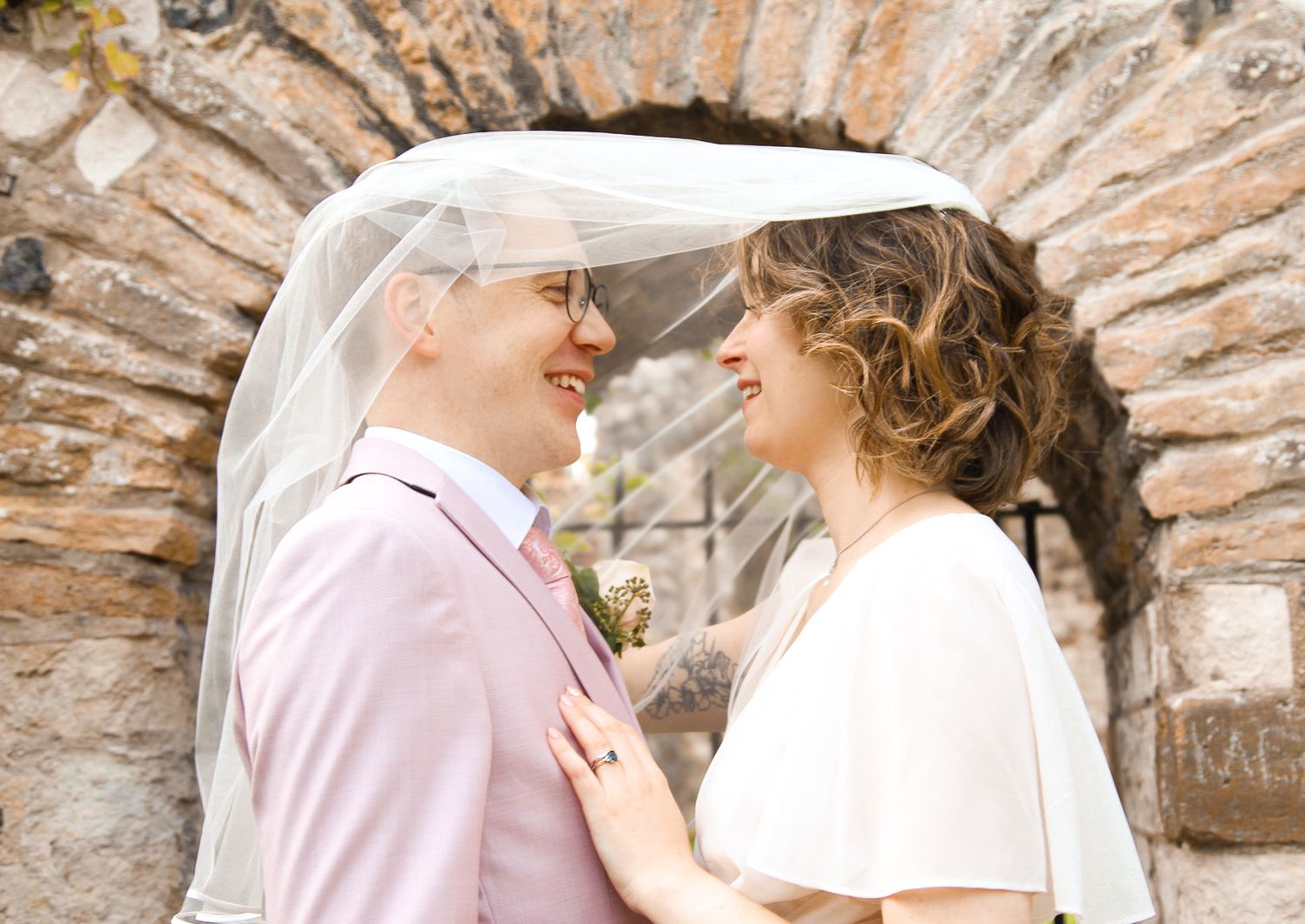 Close up shots of tender moments under an ornate stone archway.