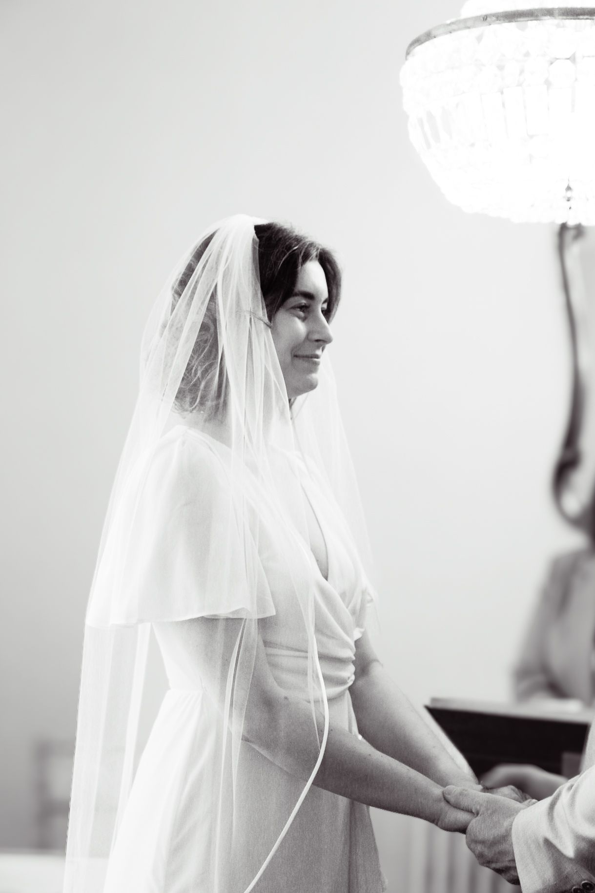 Black and white wedding photos showing close-up details of a bride in her veil and dress.