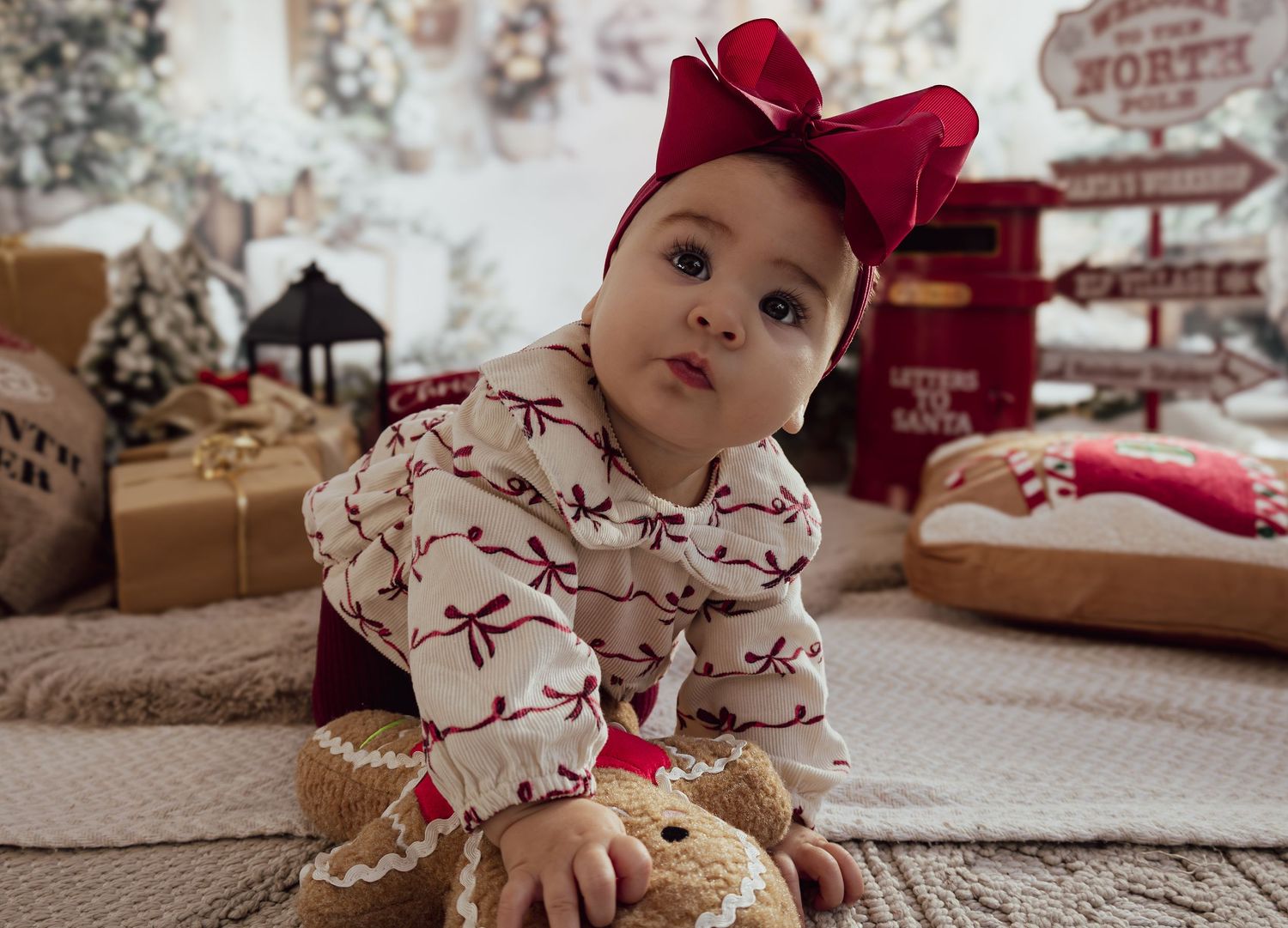 Close-up view of baby crawling on textured surface with Christmas decorations in background.