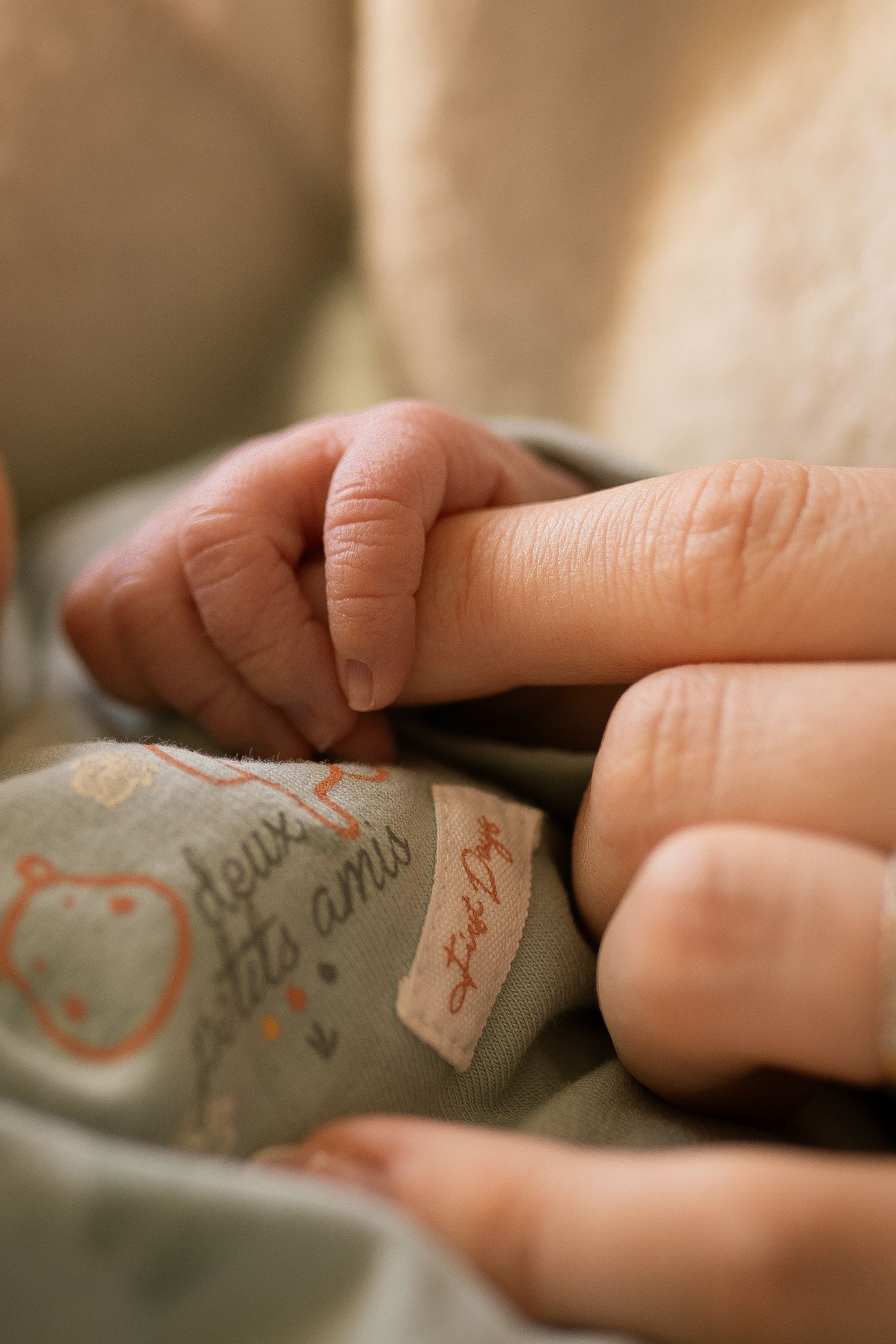 seance photo naissance et famille avec les doigts de bébé et mamans entremêlés à Marseille