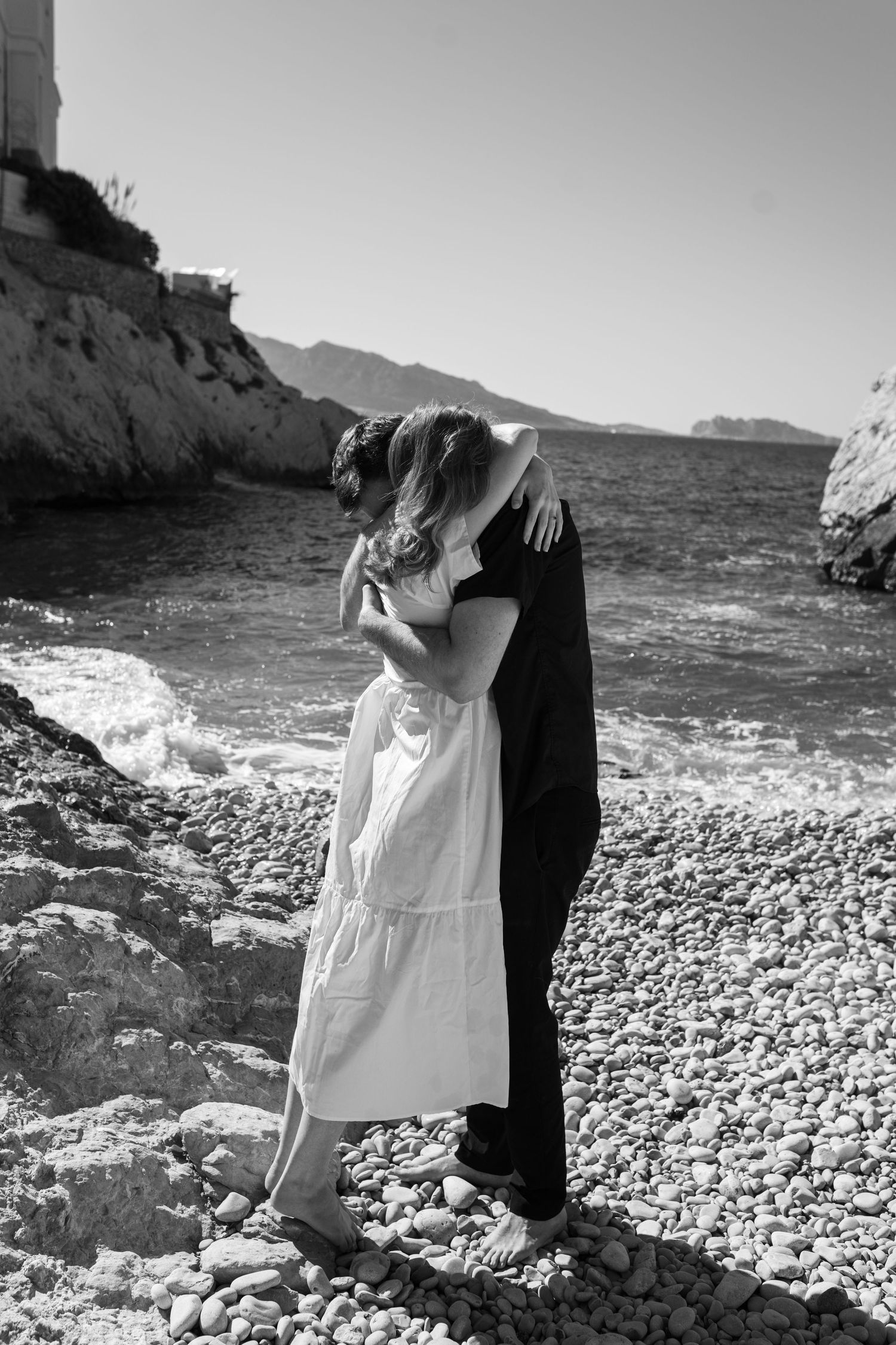 séance photo grossesse à Marseille avec un couple  qui s'enlace en bord de mer