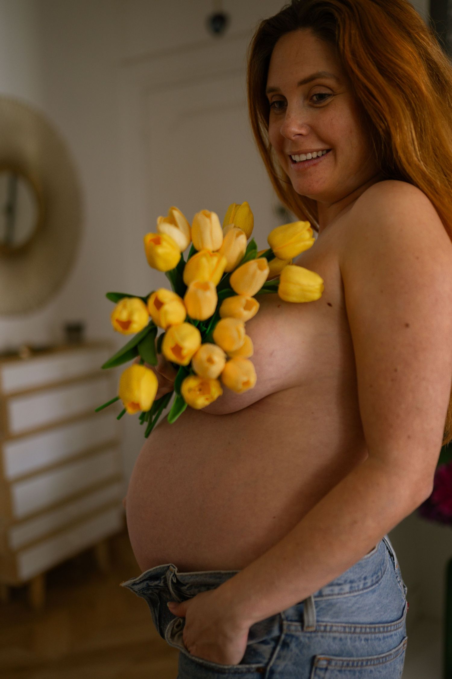 séance photo grossesse à Marseille avec une femme souriante et des fleurs jaunes