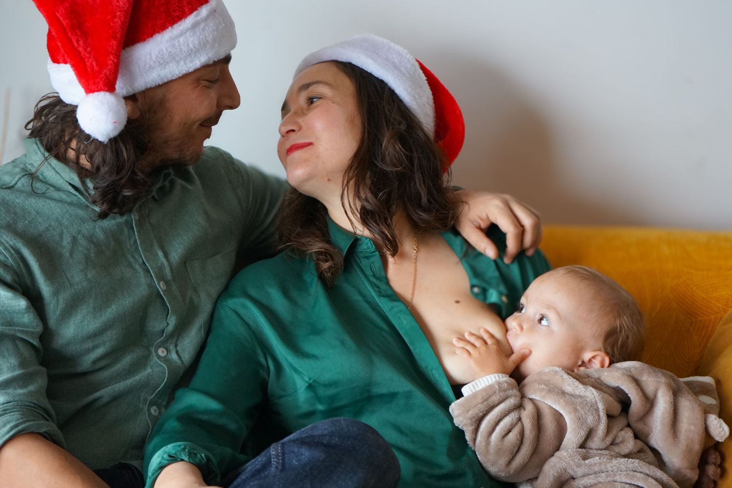 seance photo famille avec bébé et couple amoureux qui se regarde dans le canapé à Marseille