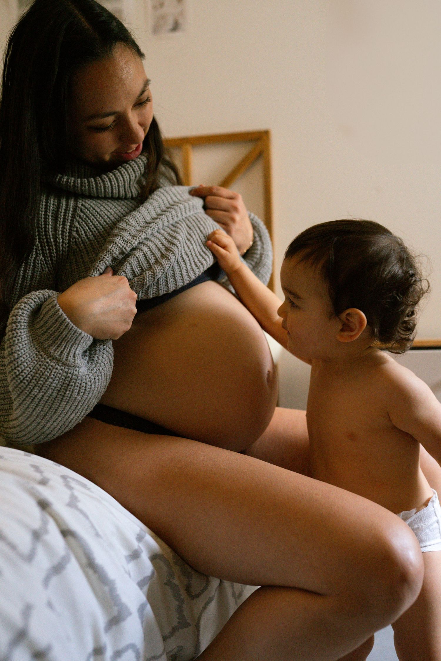 seance photo grossesse et famille avec un bébé qui touche le ventre à Marseille