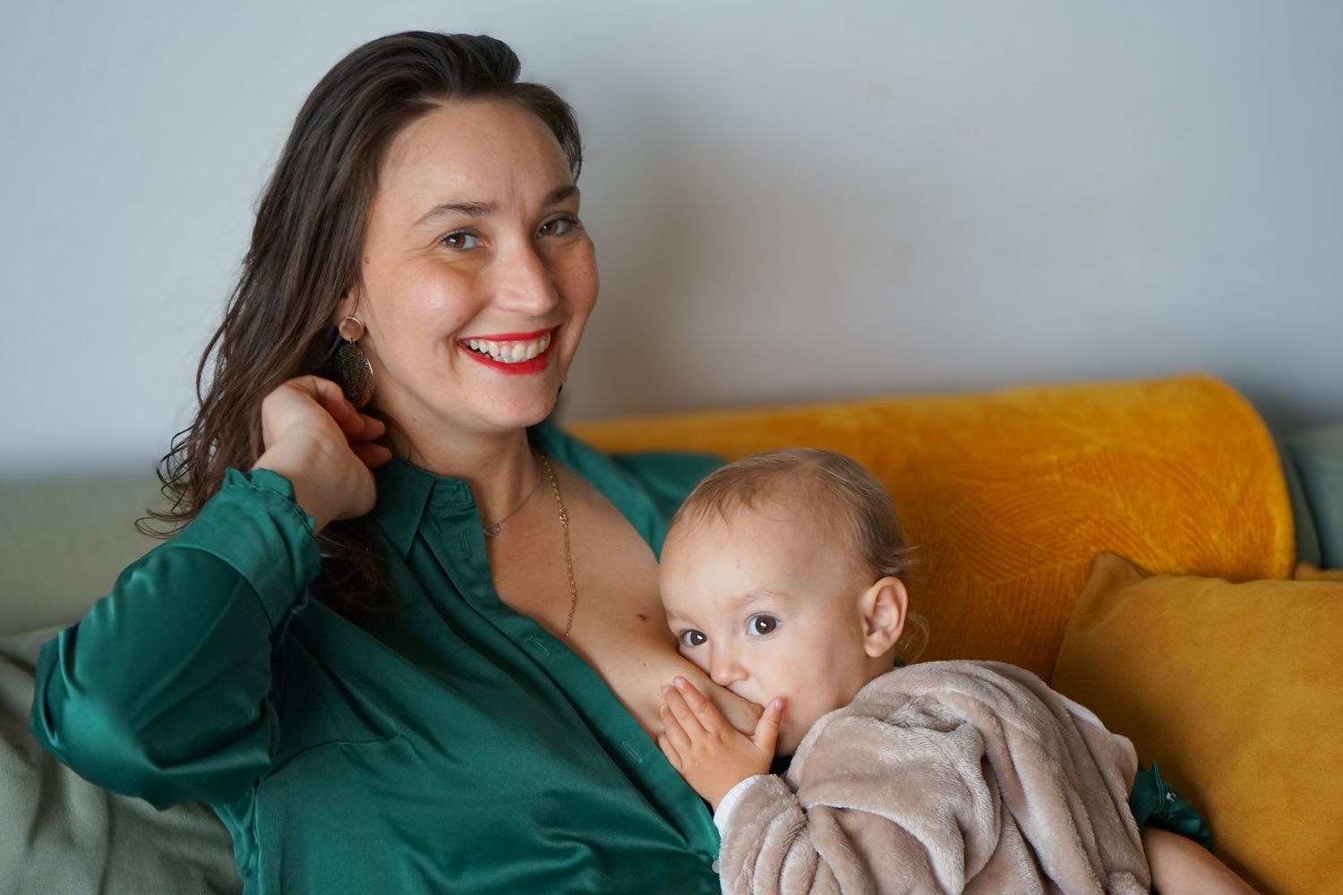 seance photo grossesse et famille avec un bébé qui tète dans le canapé à Marseille