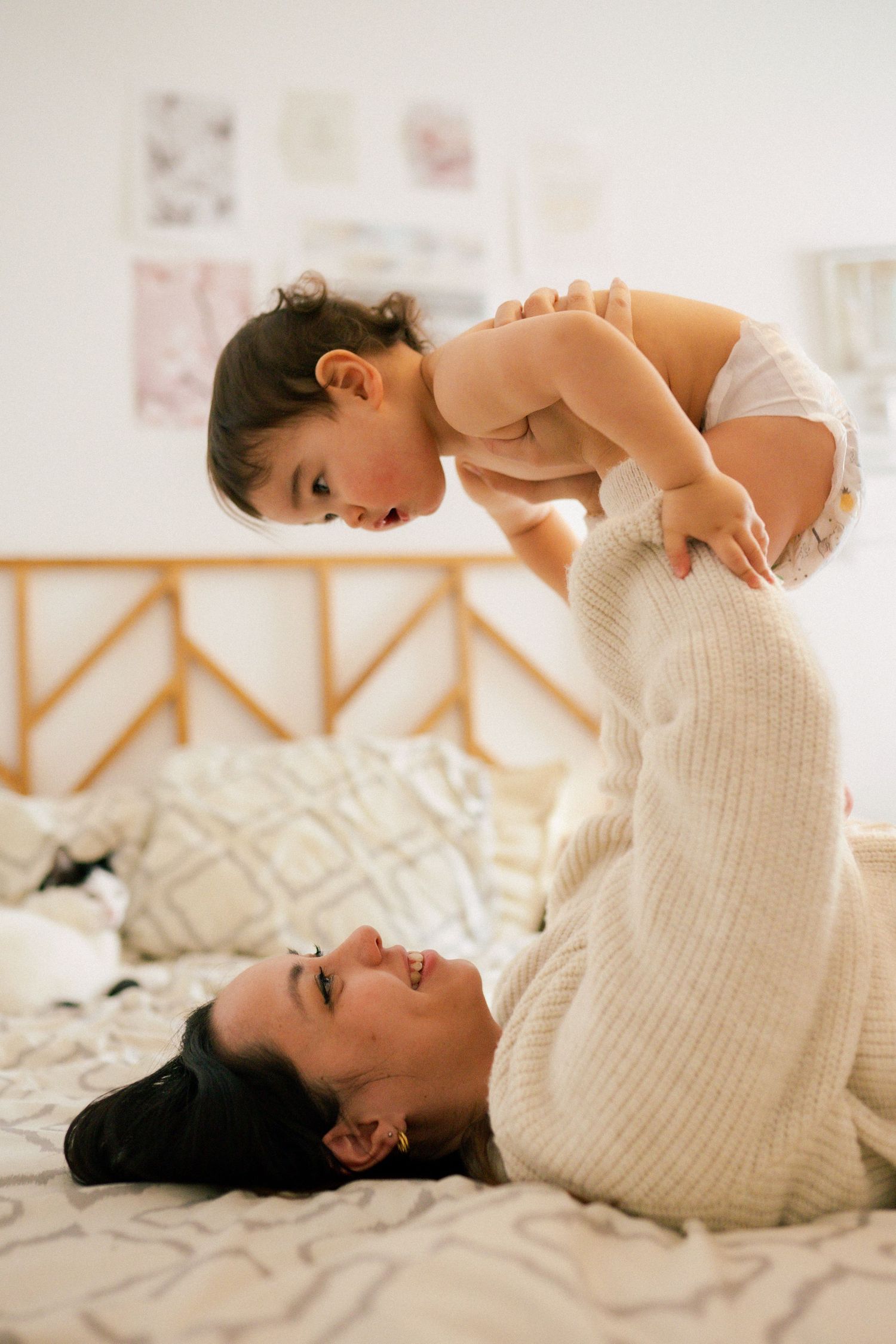 seance photo grossesse et famille avec un bébé qui joue à coté de maman dans le lit à Marseille